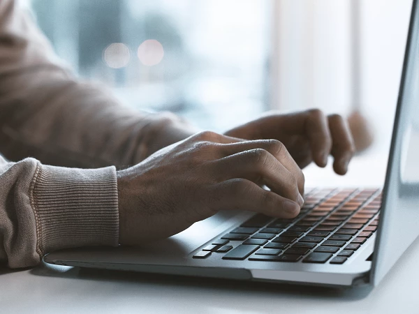 Hände auf Laptop-Tastatur bei digitaler Arbeit