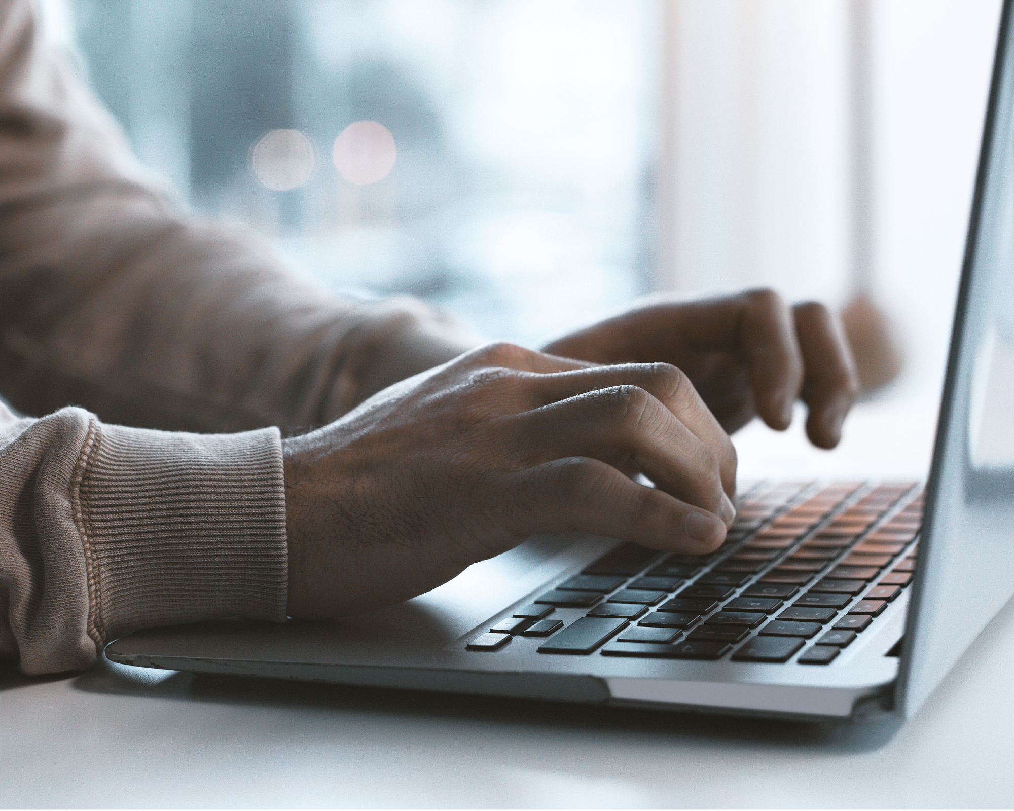 Hände auf Laptop-Tastatur bei digitaler Arbeit